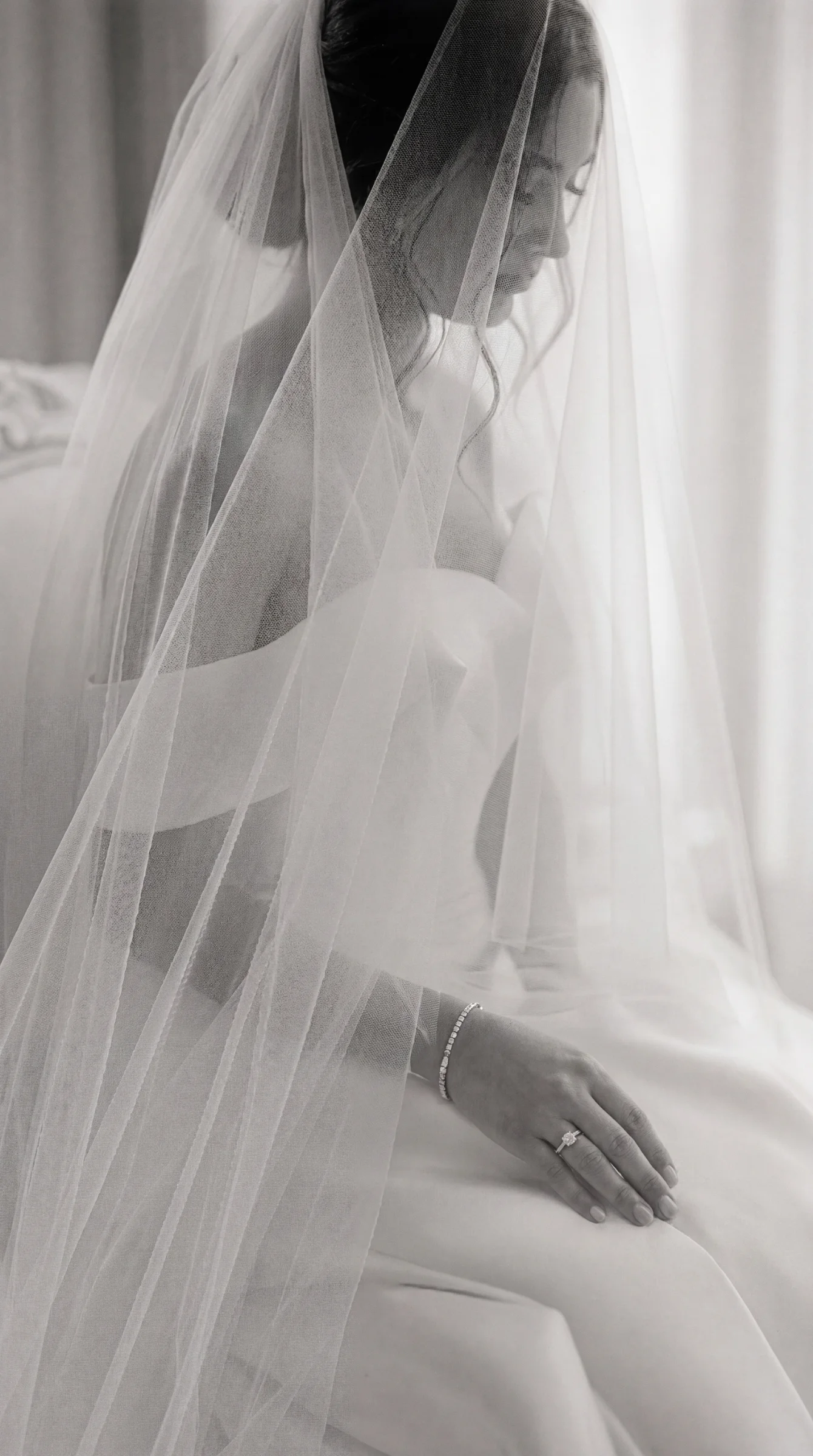 Mariée voilée en robe blanche, main ornée d'une bague de fiançailles, lors d'un reportage mariage à Montélimar