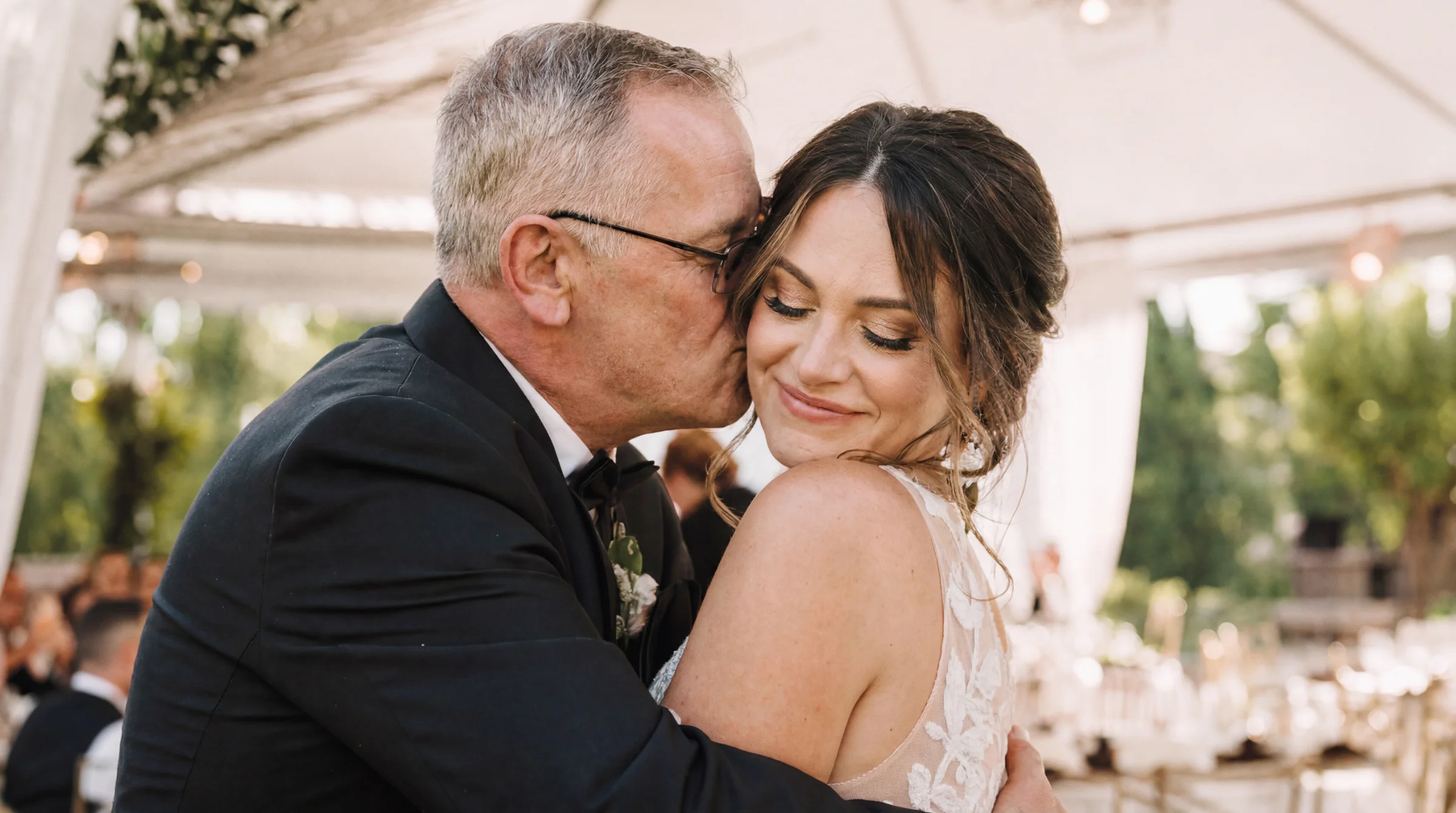 Père embrassant tendrement la mariée lors d'un reportage mariage à Montélimar, ambiance lumineuse et émotion partagée